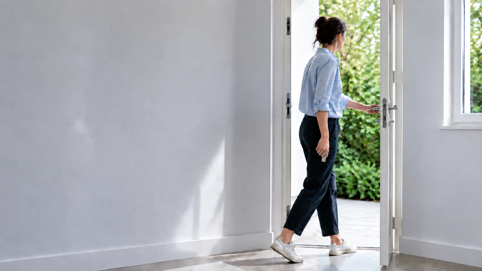 A woman leaving home with a compact titanium-tone case held naturally at her side. AI-generated lifestyle illustration.
